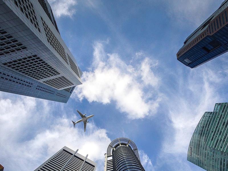 Skyscraper A view from groundlevel vertically upwards through skyscrapers, with an aeroplane flying above them