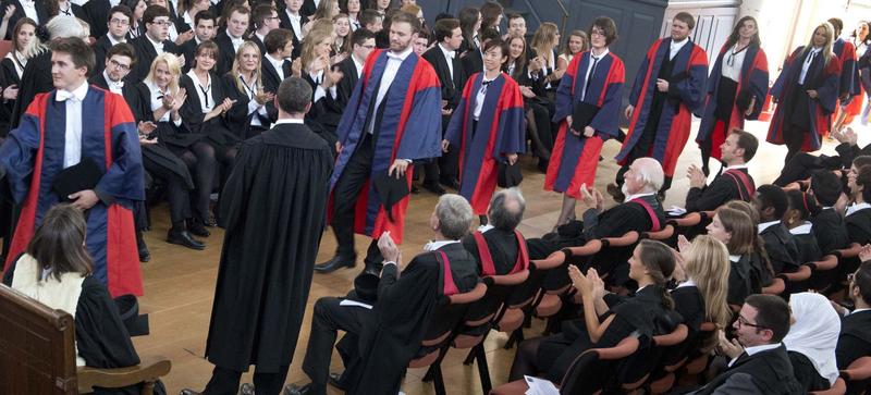 Dphils Students walking in a line to receive their graduation certificates