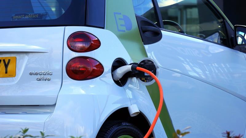 Electric car charging - Credit: Pixabay A close up picture of the back of an electric car, with the charging cable going in