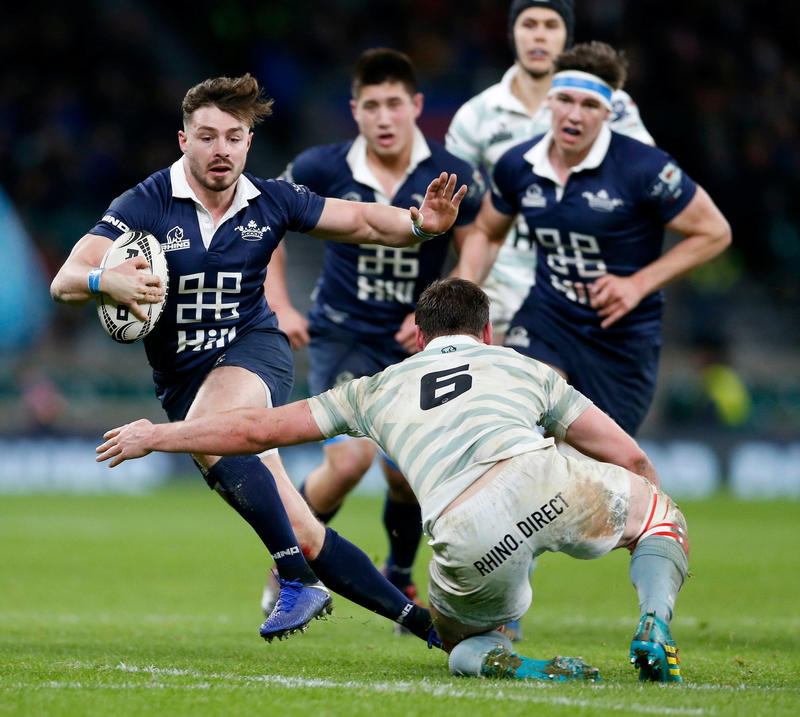 Ben Ransom, playing for Oxford in the Varsity Match, tries to evade a Cambridge tackler