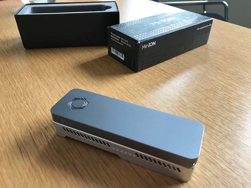 MinION - Credit: University of Oxford/Richard Lofthouse A minION device, on a table, next to the branded box from which it has been removed