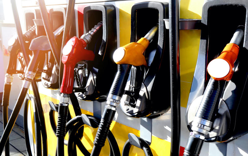 Petrol station filling nozzles, brightly coloured amidst sunshine Petrol station filling nozzles, brightly coloured amidst sunshine