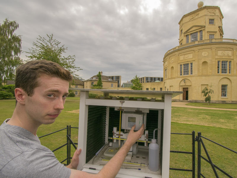 A student using scientific equipment to record the temperature in front of the Radcliffe Observatory in Oxford
