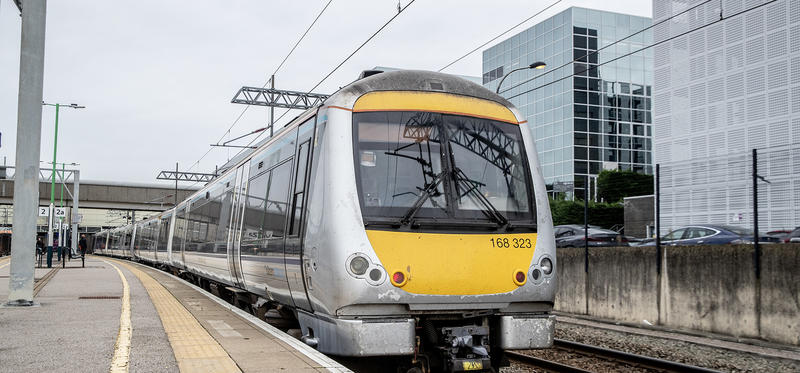 A train running on the tracks, with a cityscape in the background
