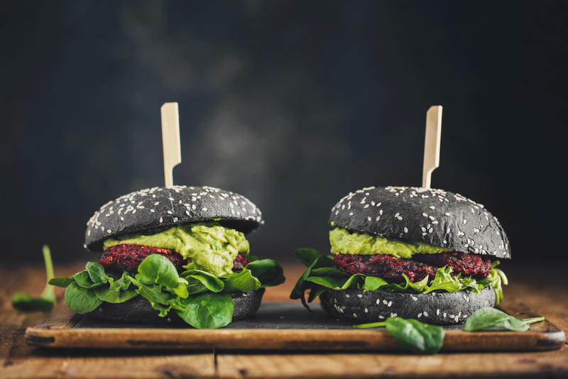 Two Vegan burgers shown on a wooden platter Two Vegan burgers shown on a wooden platter