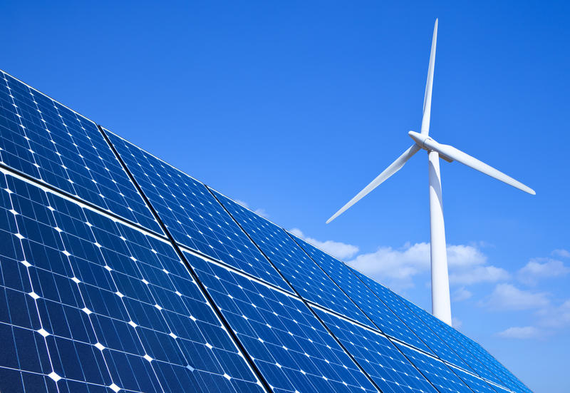 Wind turbine solar panel - credit shutterstock A wind turbine behind a solar panel